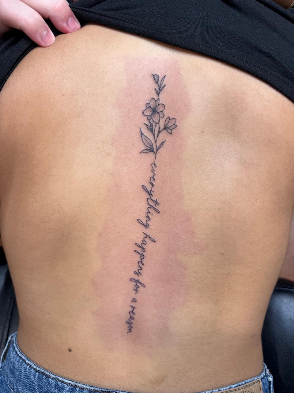 Fine line tattoo Darwin floral script spine design