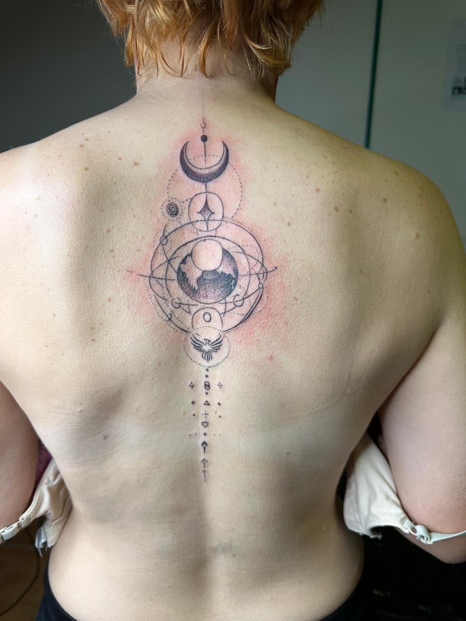 Geometric celestial spine tattoo by tattoo artist Darwin