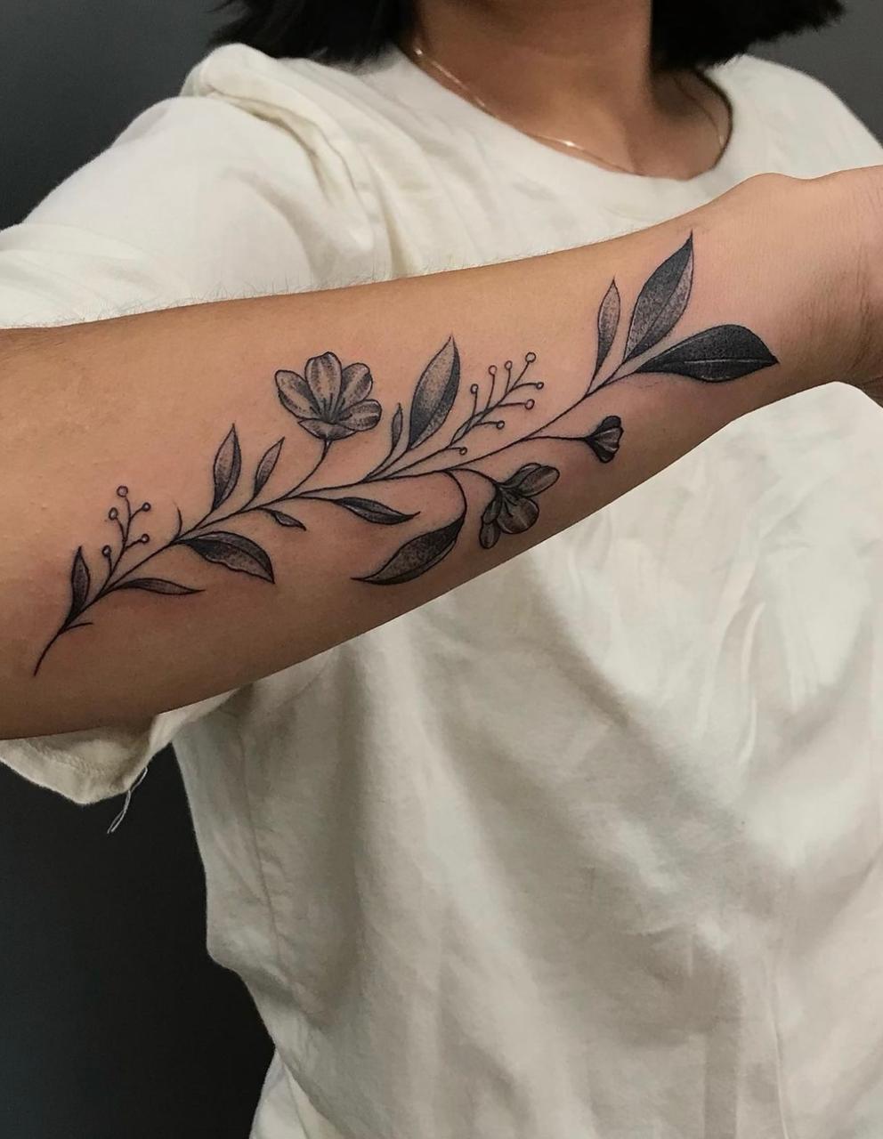 Detailed fine line floral tattoo on the forearm